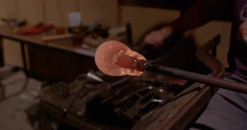 Glass Blower Forming Hot Glass in Studio