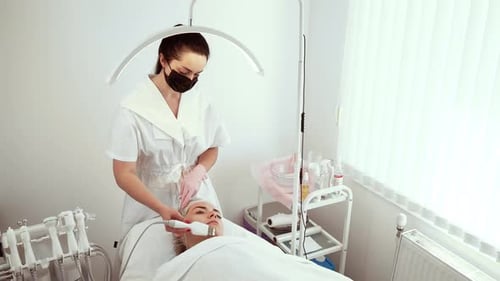 Cosmetologist Beautician Using Ultrasound Exfoliation Device During Procedure at Wellness Center