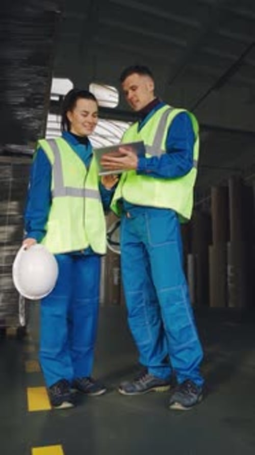 Engineers are Talking in the Warehouse of a Cardboard Factory Paper Industry Warehouse Workers