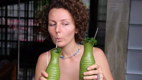 Woman Drinking Green Smoothie in Urban Setting