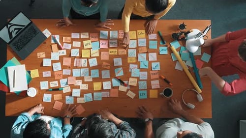 Creative Team Brainstorming Ideas Using Sticky Notes On Table