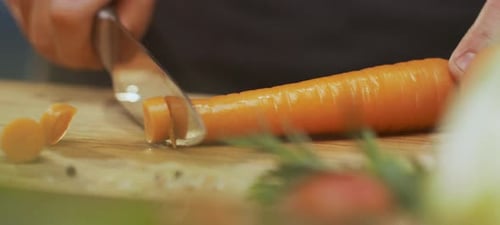 Close Up of Carrot Being Sliced on Board