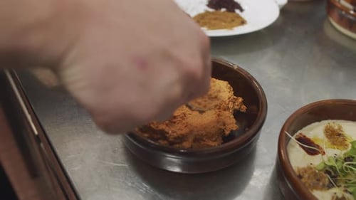 Chef prepares mediterranean starter dish. Adding nuts into the plate. Close up slow motion shot. Pla
