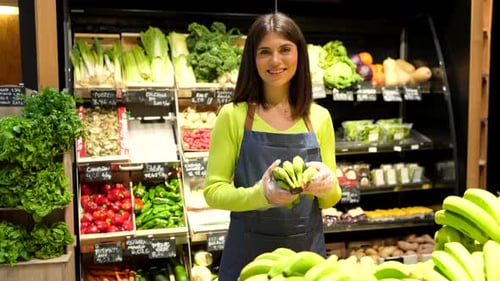 Supermarket employee showing organic green bananas