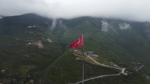 Turkish Flag Waving Over City Surrounded by Mountains