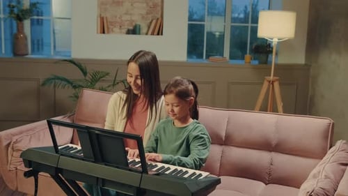 Girl Plays Piano at Home With Adult Supervision