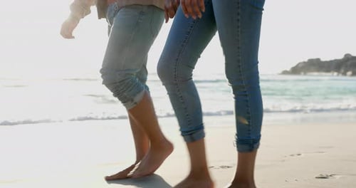 Legs, holding hands and couple walking on beach, relax or bonding on summer island holiday together