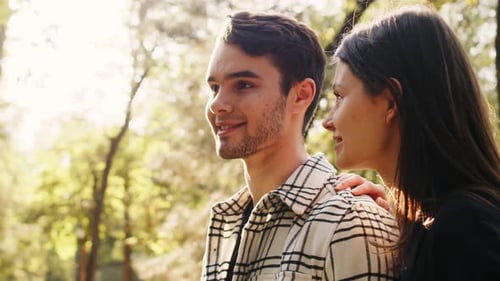 Side View Portrait of a Handsome Caucasian Man and Woman Standing and Talking Outdoors Girl Puts Her