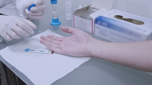 Doctor Piercing Patient's Finger for Blood Sample Testing