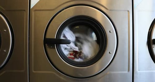 Clothes Spinning Inside Silver Industrial Washing Machine