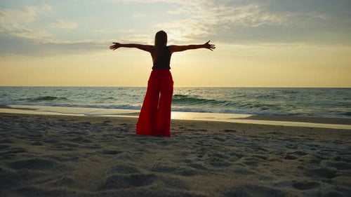 Woman on Beach Embracing Sunset