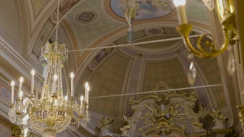 An inside view of a Catholic Church with a beautiful Chandelier and the statue of Jesus on the Cross