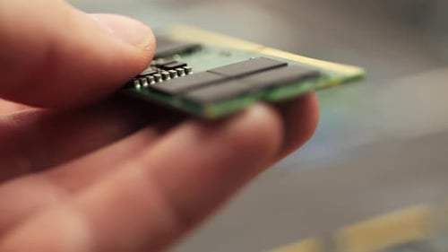 Hand Holding DDR5 RAM Module Outside Computer System