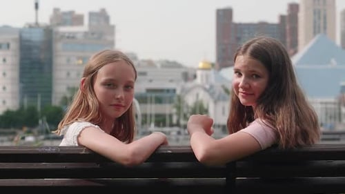 Porträt von Freunden im Teenageralter, die auf einer Bank in der Stadt sitzen