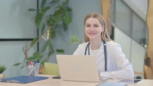 Doctor Woman Smiles at her Desk in Office