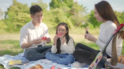 Family Enjoying Watermelon Picnic in Summer Park