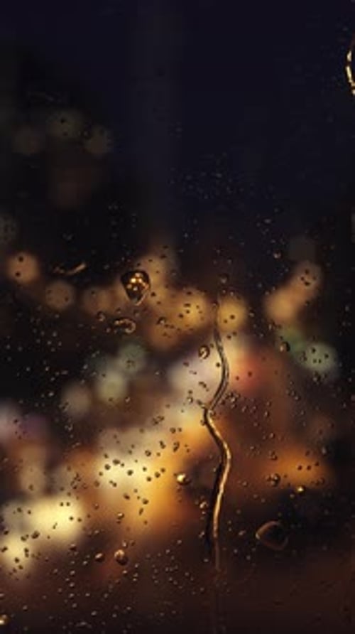 Falling rain drops on window surface.