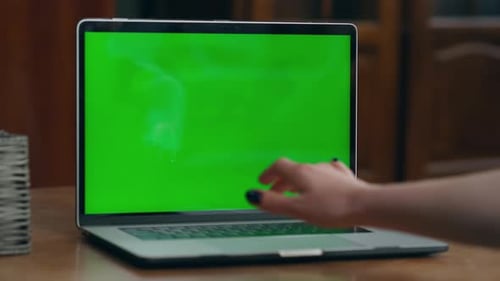 Woman Hand Turn on Green Mock-Up Screen on Modern Laptop Indoor Close