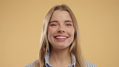 Smiling Young Woman Winking on Plain Background