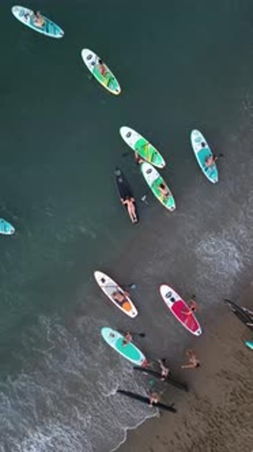 Aerial video on Barcelona's coastline people doing a sap.