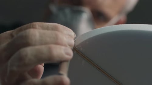 Surf board factory. Adult male shaper creates the surfing board on the factory