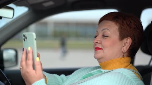 Woman Looking at Mobile Phone in Car