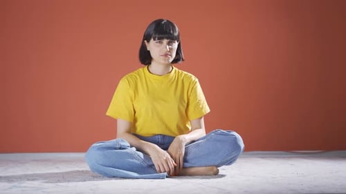 Young Woman Sitting Cross Legged on Floor