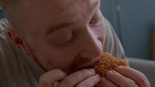 Man Eating Burger in a Close Up Indoors
