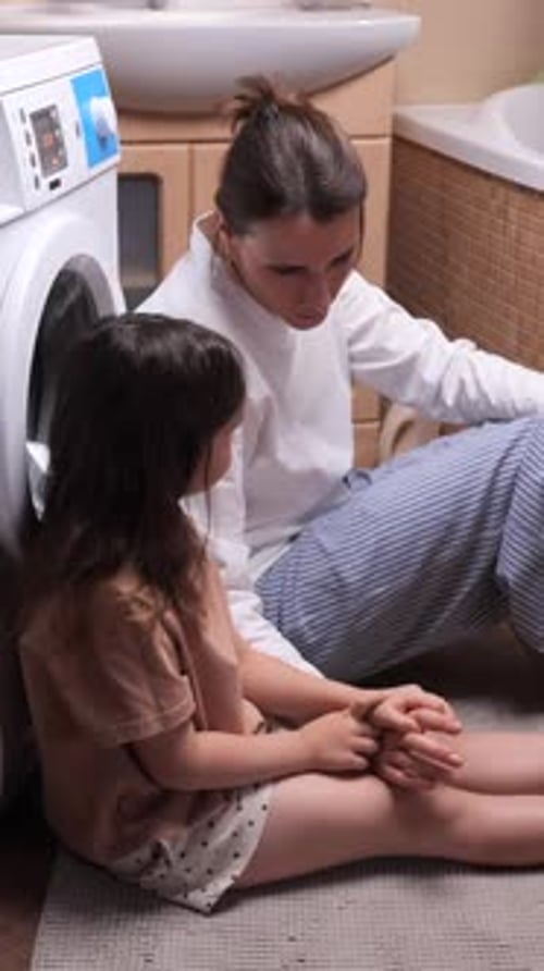 Woman and Child Sitting on Bathroom Floor