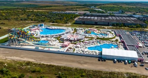 aerial hyperlapse from drone of amusement park with water rides and swimming pools