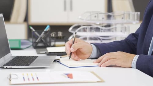 Businessman taking notes close-up.