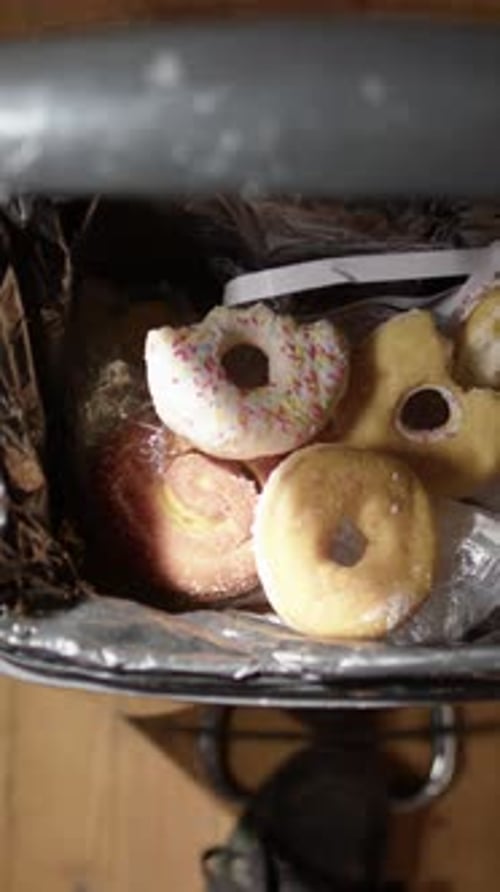 Vertical POV of dumping leftover junkfood and candies into bin