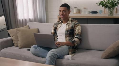Adult Using Laptop While Sitting on Couch