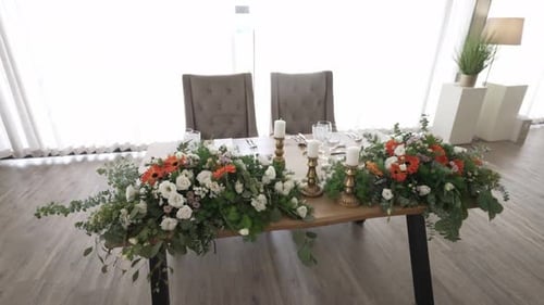 Elegant dekorierter Hochzeitstisch mit üppigen Blumenarrangements und Kerzenakzenten.