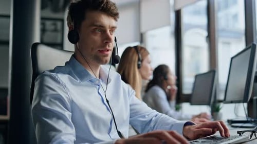 Call Center Operator Working at Computer in Office