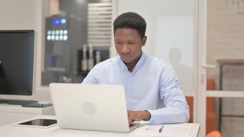 African Businessman Working on Laptop in Office