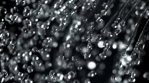 Water Droplets Falling in Slow Motion Against Dark Background