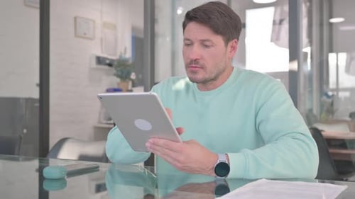 Man Using Tablet at Office Glass Table