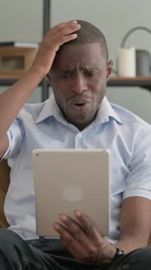 Concerned Man Using Tablet Indoors