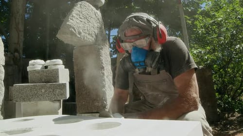 Craftsperson Working with Angle Grinder on Stoneware Outdoors