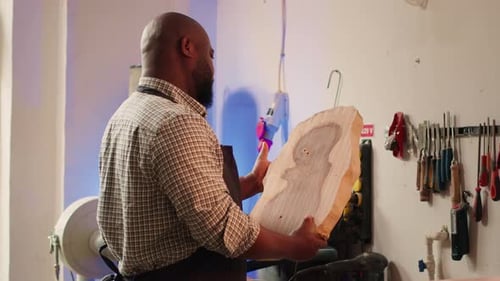 Portrait of Smiling Carpenter in Woodworking Shop Inspecting Wood Block