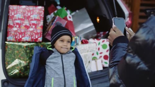 Boy With Gifts Poses While Photo Taken