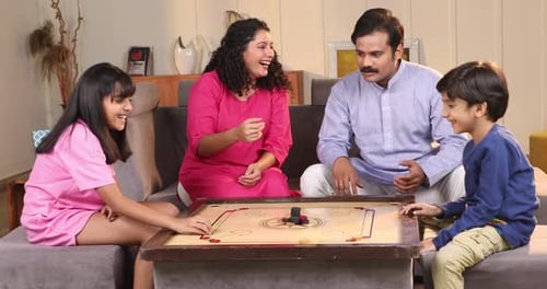 Family Laughs Together Playing a Board Game at Home