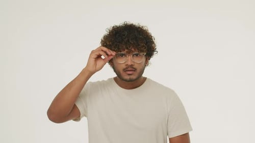 Surprised Bearded Guy Takes Off His Glasses in Amazement Front View of Indian Young Man Expressing