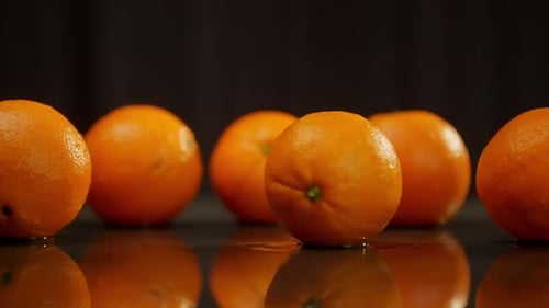 Five Oranges on Wet Reflective Surface