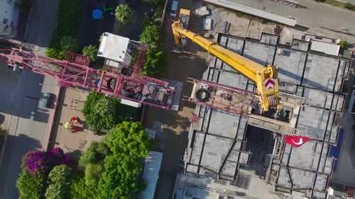 Aerial View Operator Climbs Tall Ladders Confidently Mounting Parts with Care on a Massive Crane