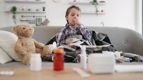 Sick Child Coughing on Couch