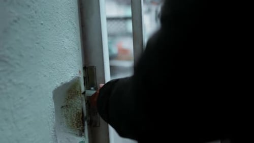 50s African Descent Man from South America Descending Stairs to Open Residence Gate, Venturing Out