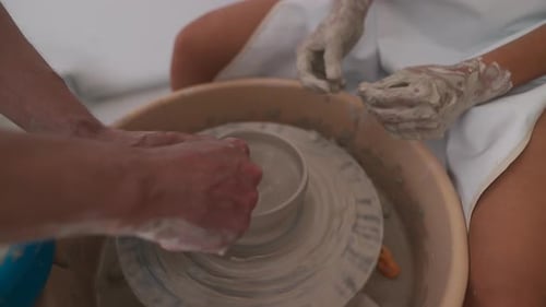 Potters Crafting Clay Bowl on Pottery Wheel