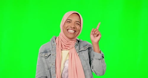 Muslim, face and happy woman pointing on green screen, studio and mockup background